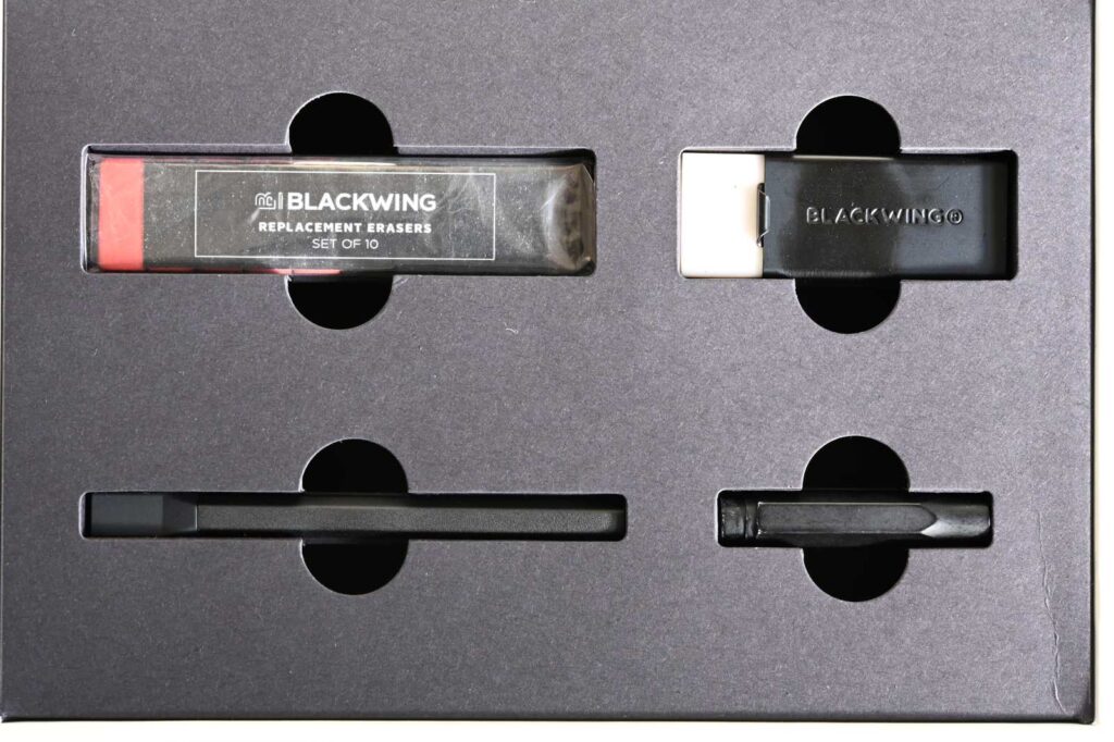 ブラックウイング×モレスキン アトリエセットの画材の部分。ブラックウイングの鉛筆の消しゴムの替え、消しゴム、キャップ、鉛筆ホルダーをはっきり見えるように撮影。