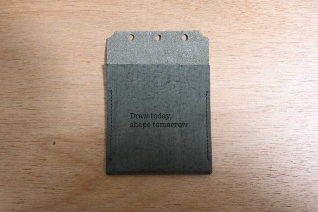 plotterのA5サイズを買ったときについてきた特典。濃い緑色で、3つの穴があいていて取り付けられる。Draw today, shape tomorrowと書いている。