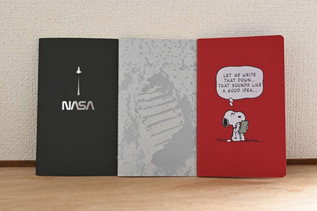 モレスキン カイエジャーナルの3冊比較。左からNASA限定版の黒とグレー(無地)、右はスヌーピーコラボの赤い表紙(罫線)。