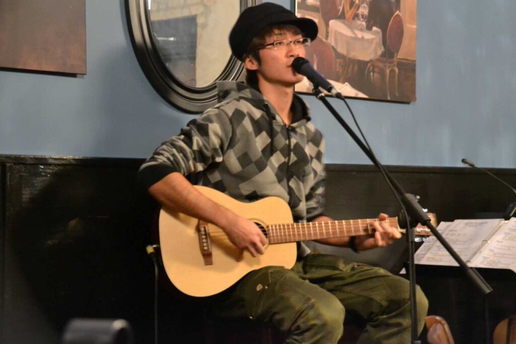 上達の研究家ワタタクがカナダワーキングホリデー期間に、カフェでアコースティックギター弾き語りをしていた写真。