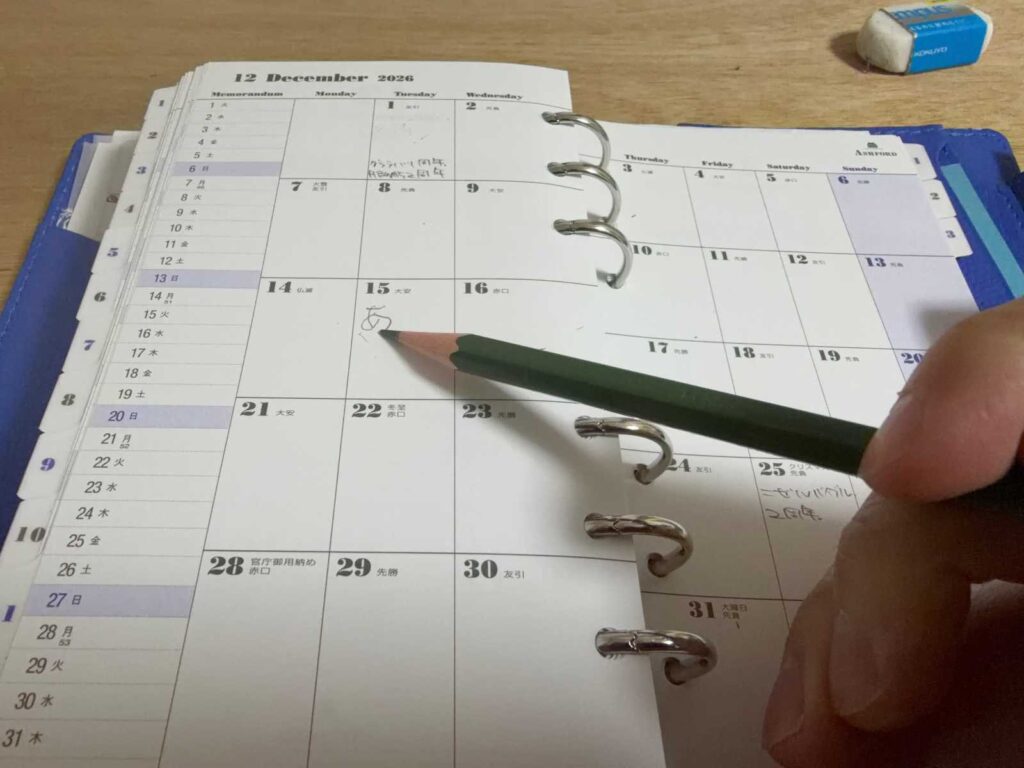 トンボ鉛筆8900 Bの長さを活かし、リングを飛び越えてペン先を紙面に届かせるクローズアップ。左利き・右利き問わず有効なシステム手帳の筆記ハック。